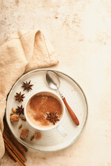 Masala tea. Masala chai spiced tea with milk and spices on light warm beige background. Traditional...