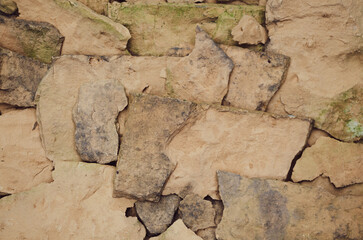 Fototapeta premium wall of broken old red brick with green moss around the edges wallpaper