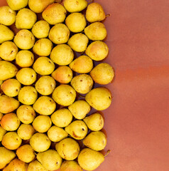 Many pears arranged in rows and columns on a brown background