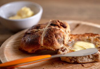 A toasted and buttered Hot Cross Bun, a sweet spiced bun traditionally eaten on Good Friday