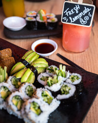 Fototapeta na wymiar Eating sushi in Asian restaurant. Sushi, soup and homemade lemonades.