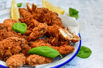 
 Crispy  deep fried   chicken strips and wedges potato. Breaded  with cornflakes chicken  breast fillets  with chilly peppers and fresh   basil on wooden rustic background