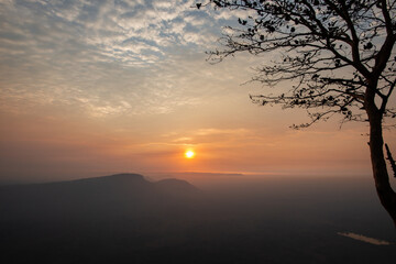 The sun rises at the top of the mountain with a faint mist.