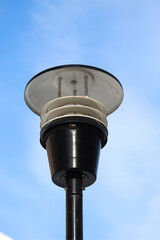 beautiful black metal lighting lamppost on blue sky background