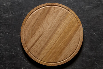 Round wooden pizza stand board, top view dark background, with space to copy text..