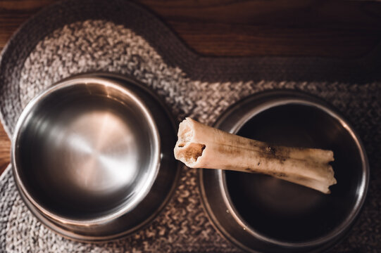 Overhead View Of A Dog Chew Bone In Metal Bowl.