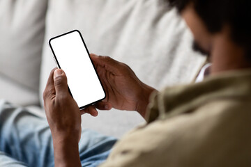 Unrecognizable Black Male Using Smartphone With Blank White Screen At Home