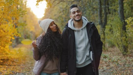 Happy young couple in love enjoy pleasant walk walking in autumn park holding hands communicate talking smiling share dream spend weekend together romantic date in nature romance relationships concept