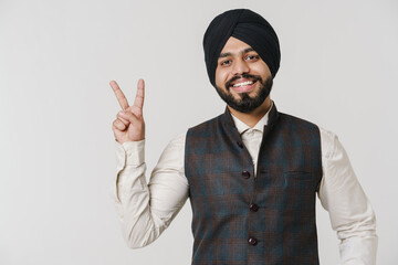 Bearded south asian man wearing turban smiling and gesturing