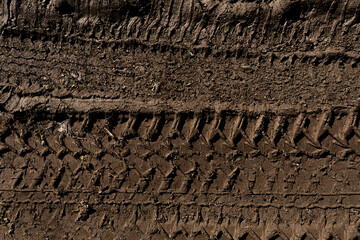 Tyre track on dirt sand or mud, Picture in retro or grunge tone. Car drive on sand. off road track. Track on grass field. Track in farm.	