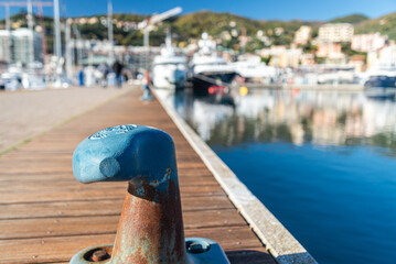 Iron mooring at the marina of Varazze, Liguria, Italia. Blurred vessels and yachts on the...