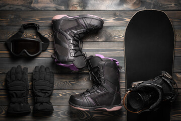 Snowboarding equipment on the wooden flat lay background.