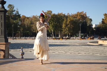 Young flamenco woman, Hispanic and brunette, with typical flamenco dance suit, with bullfighter...