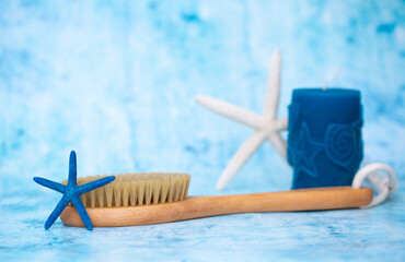 Massage brush for the body. Dry lymphatic drainage massage. Wooden brush made of cactus and boar fiber. On a blue background with starfish. Bathroom treatments. Homemade body care.