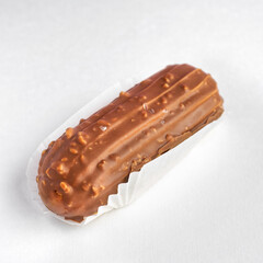 Traditional french dessert. eclair with custard and milk chocolate icing on white background. Pastry products for sweet tooth