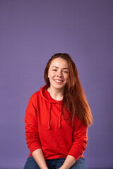 Smiling caucasian red hair woman on purple background