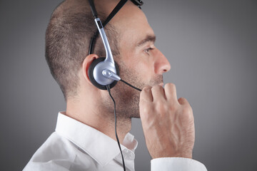 Caucasian customer support operator with headset in office.