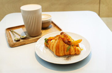 Croissant with salmon and egg on a cafe table. Shallow focus.