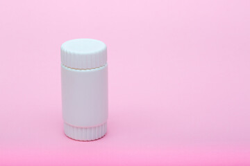 White different medecine or cosmetic jars on a pink background as a concept of cosmetology of medecine and treatment