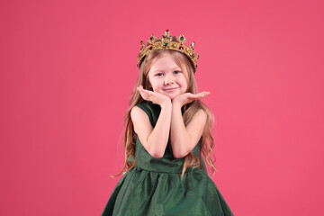 Cute girl in fairy dress and golden crown with gems on pink background. Little princess