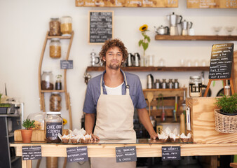 Obraz premium We have everything you can think of. Portrait of a male barista standing at a cafe counter.