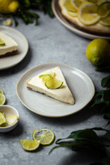 part de cheesecake citron speculoos fait maison sur table avec agrumes et feuilles vertes