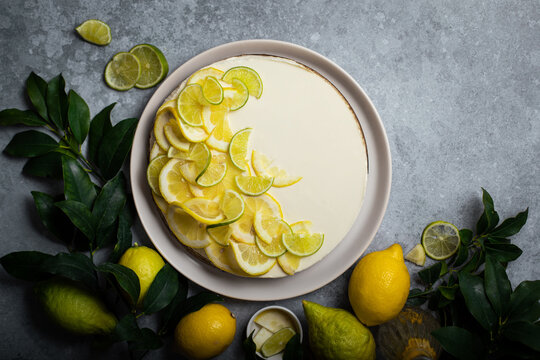 cheesecake citron speculoos fait maison sur table avec agrumes et feuilles vertes