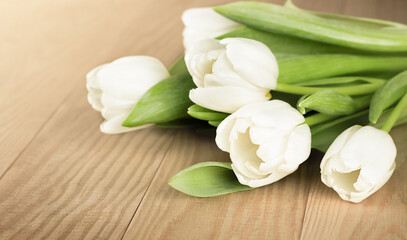 Fototapeta na wymiar bouquet of white tulips on a wooden table