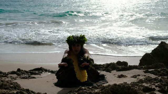 Beautiful woman performing hawaiian dancing at the beach