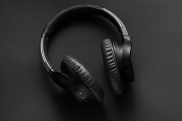 Black wireless headphones on a black background