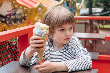 Kid enjoys ice-cream in the park