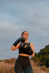 fit young girl with boxing gloves outdoors