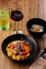 chicken curry with a black plate on a wooden background. restaur