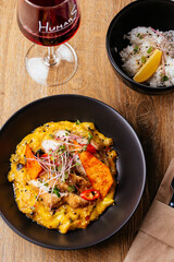 chicken curry with a black plate on a wooden background. restaur