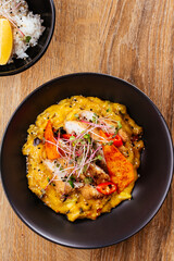 chicken curry with a black plate on a wooden background. restaur