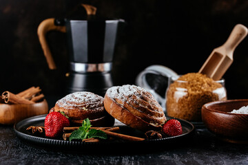 cinnamon buns on a dark background. coffee, sugar, berries