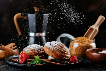cinnamon buns on a dark background. coffee, sugar, berries