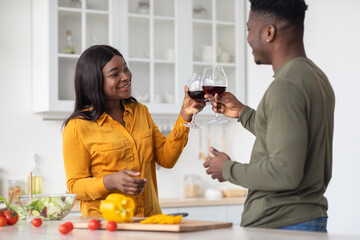 Young Romantic Black Spouses Drinking Wine And Cooking Food In Kitchen