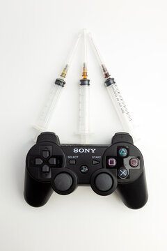 sony playstation controller and medical syringes, Video game addiction concept