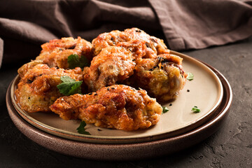 Fried chicken legs, breaded, with spices and herbs, on a dark background, horizontal, no people, selective focus, toned.