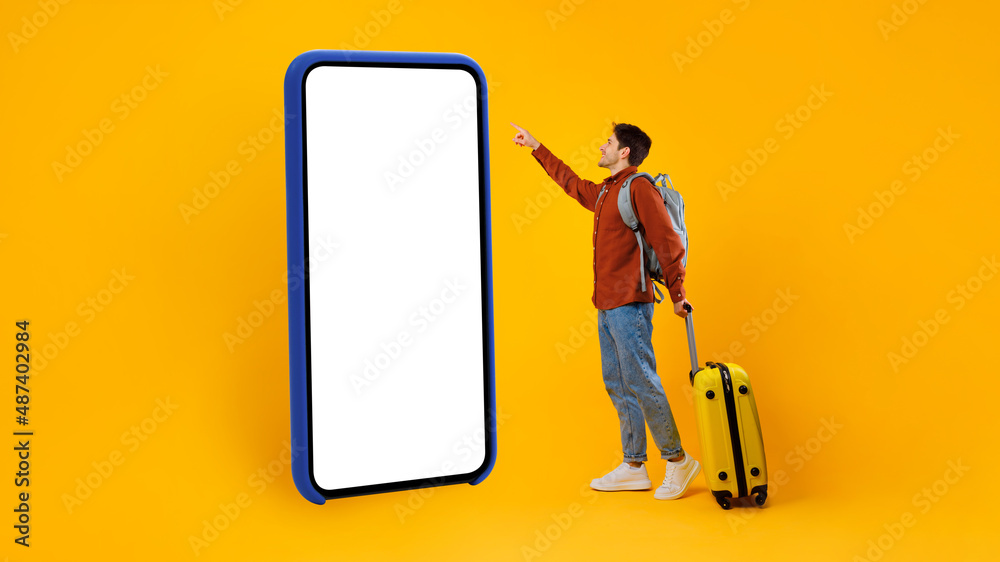 Poster tourist guy using huge cellphone with empty screen, yellow background