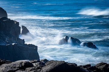 Fisherman on rocks at Oregon coast with waves