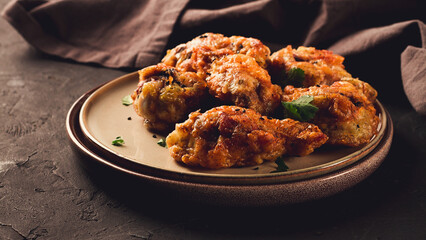 Fried chicken legs, breaded, with spices and herbs, on a dark background, horizontal, no people, selective focus, toned.