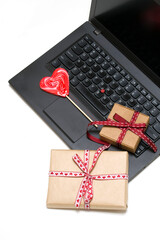 vertical photo. laptop, two gift boxes, heart shaped lollipop on white background.card, congratulations on Valentine's Day, Mother's Day. romantic background 