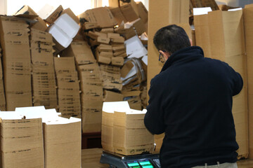 selective focus: packaging of hamburger and sandwich boxes. Personnel packing in kraft boxes in equal numbers to be sent to the customer