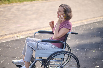 A woman on wheel-chair looking excited and feeling happy