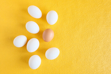 Chicken eggs white and brown Farm product. Yellow background. Easter concept.