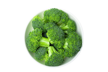 Raw broccoli pieces in a bowl isolated on white background, top view.