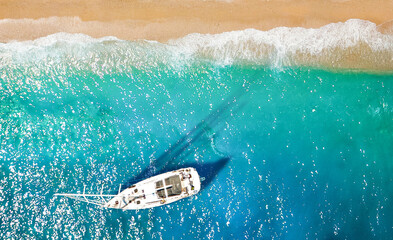 Wellen und Yacht von oben. Türkisfarbener Wasserhintergrund von oben. Sommermeerblick aus der Luft. Draufsicht von der Drohne. Reisebild