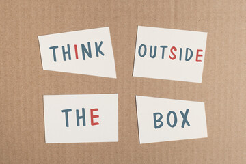 Think outside the box is standing on pieces of white paper, brainstorming for new ideas, being innovative, business concept